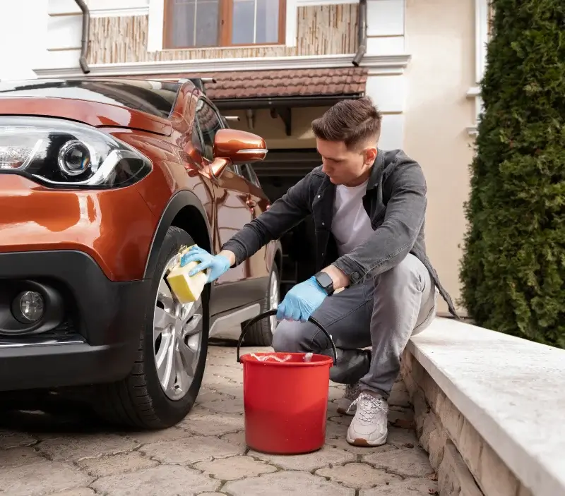 Lavage auto à domicile Le Mesnil-au-Val : professionnel intervenant sur un véhicule